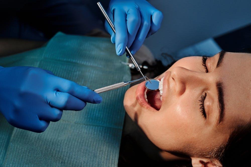 A woman undergoing a procedure with the dentist who can be a part of a dental marketing strategy