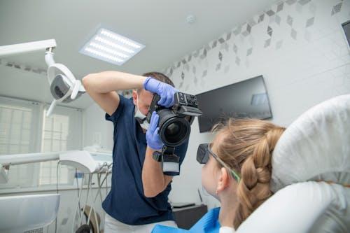 A dentist taking a real practice image of a young patient during a dental procedure